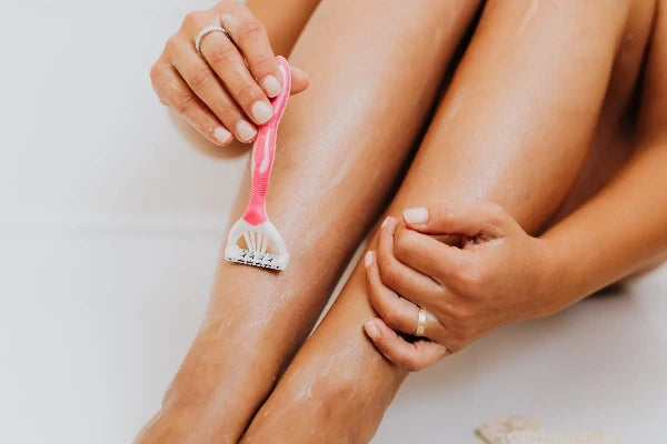 Women shaving legs with shaving cream 